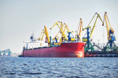 Kömür terminalinde büyük bir kargo gemisi (kargo gemisi), yakın plan. Arka planda iskele vinçleri. Krievu Adası, Riga, Letonya. Yük taşımacılığı, yakıt ve enerji üretimi, çevresel hasar