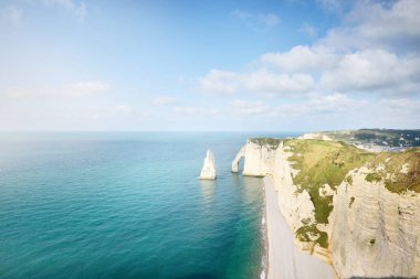 Gün batımında Etretat beyaz uçurumlarının manzaralı panoramik görüntüsü. Dramatik gökyüzü, gök mavisi su. Fransa, Normandiya 'da yaz tatili. Seyahat yerleri, ulusal dönüm noktaları, geziler, tarih.