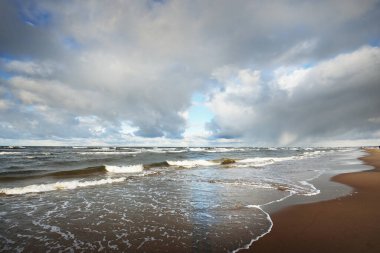 Baltık Denizi üzerinde fırtına bulutları, kışın kasırga. Dramatik gökyüzü, dalgalar ve su sıçramaları. Almanya. Ekoloji, iklim değişikliği, küresel ısınma kavramları