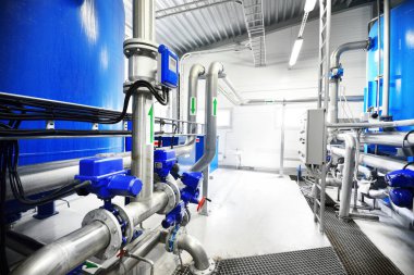 Large blue tanks in a industrial city water treatment boiler room. Wide angle perspective clipart