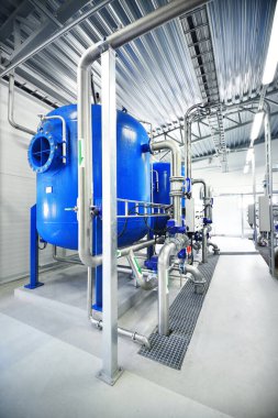 Large blue tanks in a industrial city water treatment boiler room. Wide angle perspective clipart
