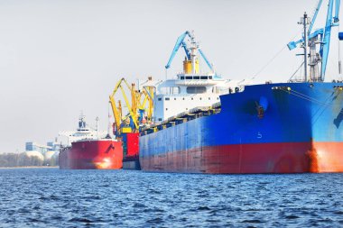 Kömür terminalinde büyük bir kargo gemisi (kargo gemisi), yakın plan. Arka planda iskele vinçleri. Krievu Adası, Riga, Letonya. Yük taşımacılığı, yakıt ve enerji üretimi, çevresel hasar