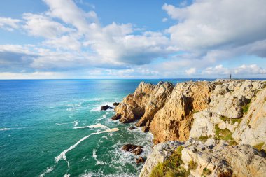 Pointe de Pen-Hir 'in kayalık sahili, uçurumlara yakın. Bulutlu mavi gökyüzü, masmavi su, fırtınalı dalgalar. Dramatik bulut manzarası. Crozon Yarımadası, Britanya, Fransa