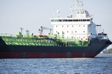 Büyük siyah tanker (kargo gemisi) limana yaklaşıyor, yakın plan. Riga Körfezi, Baltık Denizi, Letonya. Yük taşımacılığı, küresel iletişim, lojistik, çevresel hasar teması