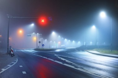 Gece sisli bir ortamda bomboş bir otoyol. Sokak lambaları ve yol işaretleri yakın. Karanlık şehir manzarası, şehir manzarası. Riga, Letonya. Tehlikeli sürüş, hız, özgürlük, konsept görüntü
