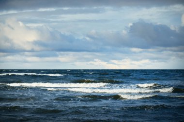 Baltık Denizi üzerinde fırtına bulutları, kışın kasırga. Gün batımının destansı gökyüzü, dalgalar ve su sıçramaları. Koyu deniz manzarası. Almanya. Ekoloji, iklim değişikliği, küresel ısınma kavramları