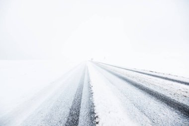 Kar fırtınası sonrasında kırsal alanlarda karla kaplı otoyol (asfalt yol) sisli bir havada. Tehlikeli sürüş, iklim değişikliği, küresel ısınma, ekoloji, çevre koruma