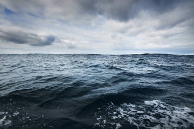 Yelkenli bir tekneden fırtınalı Kuzey Denizi manzarası. Bulutlu mavi gökyüzü suya yansıyor. Dramatik bulut manzarası. Rogaland bölgesi, Norveç. Boş zaman aktiviteleri, çevresel koruma kavramları