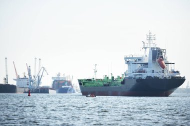 Büyük siyah tanker (kargo gemisi) limana yaklaşıyor, yakın plan. Riga Körfezi, Baltık Denizi, Letonya. Yük taşımacılığı, küresel iletişim, lojistik, çevresel hasar teması