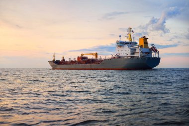 Büyük gri bir tanker gün batımında Europort 'tan denize açılacak. Renkli akşam bulutları. Rotterdam, Hollanda. Lojistik, ticaret, küresel iletişim teması
