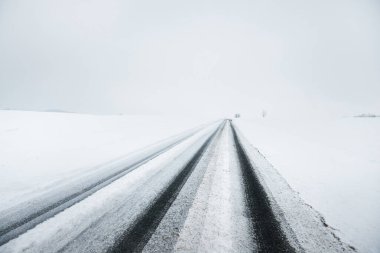 Kar fırtınası sonrasında kırsal alanlarda karla kaplı otoyol (asfalt yol) sisli bir havada. Tehlikeli sürüş, iklim değişikliği, küresel ısınma, ekoloji, çevre koruma