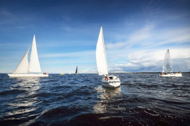 Yelkenli yat yarışı. Modern yelkenliler yakın plan. Fırtınadan sonra dramatik mavi gökyüzü. Muazzam bulut manzarası. Kuzey Almanya, Kiel
