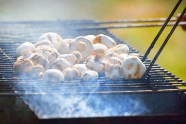 Kömür mantarı ızgarası ve yakın plan sigara. Mutfak, sağlıklı beslenme, yaşam tarzı, organik, vejetaryen, vegan yemekleri, yemek pişirme, yaz tatilleri teması