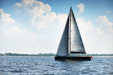 Sıcak bir yaz gününde, yakın planda, modern pahalı bir yat gezisi. Dramatik bulut manzarası. İngiltere