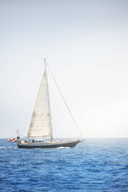 Açık bir günde, açık bir Akdeniz 'in durgun sularında yelken açan zarif bir Alman yatı. Idyllic deniz manzarası. Yaz tatilleri, boş zaman aktiviteleri, spor ve eğlence, özel gelincik.