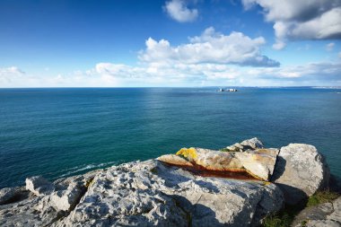 Pointe de Pen-Hir 'in kayalık sahili, uçurumlara yakın. Bulutlu mavi gökyüzü, masmavi su, fırtınalı dalgalar. Dramatik bulut manzarası. Crozon Yarımadası, Britanya, Fransa