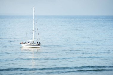 Beyaz yat, Fransa 'nın Brittany kıyısındaki Kelt Denizi' nin bir körfezinde demirliyor. Panoramik deniz manzarası. Yelkencilik, spor, eğlence, gezi, eğlence aktivitesi, denizcilik gemisi, ulaşım.