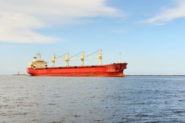 Europoort 'tan denize açılan bir vinçle büyük kırmızı bir yük gemisi (kargo gemisi). Açık mavi gökyüzü ve sirrus bulutları. Rotterdam, Hollanda. Küresel iletişim, lojistik, endüstri teması