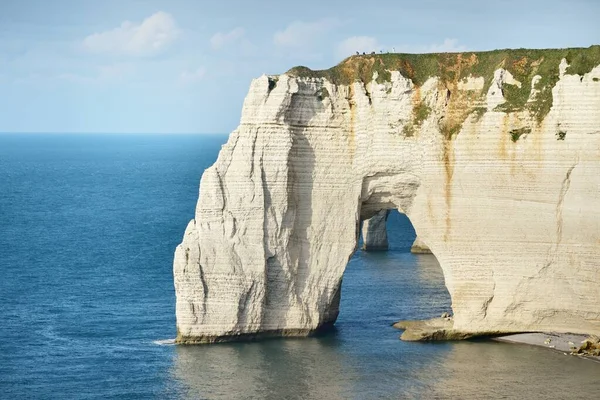 Gün batımında Etretat beyaz uçurumlarının manzaralı panoramik görüntüsü. Dramatik gökyüzü, gök mavisi su. Fransa, Normandiya 'da yaz tatili. Seyahat yerleri, ulusal dönüm noktaları, geziler, tarih.