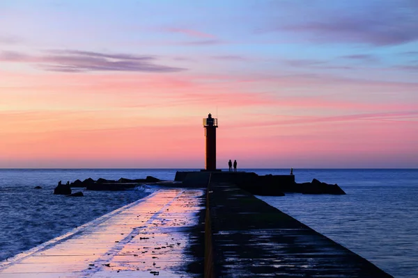 Een Paar Mensen Bij Oranje Vuurtoren Kleurrijke Zonsondergang Hemel Prachtig — Stockfoto