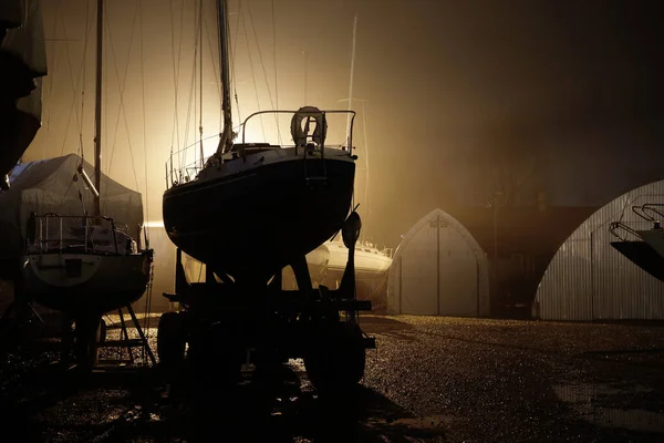 帆船在夜间大雾中站在陆地上 过冬的游艇在等待新赛季的开始 拉脱维亚里加的游艇俱乐部 私人船只 设备和服务 — 图库照片