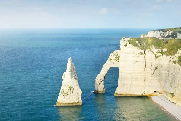 Gün batımında Etretat beyaz uçurumlarının manzaralı panoramik görüntüsü. Dramatik gökyüzü, gök mavisi su. Fransa, Normandiya 'da yaz tatili. Seyahat yerleri, ulusal dönüm noktaları, geziler, tarih.