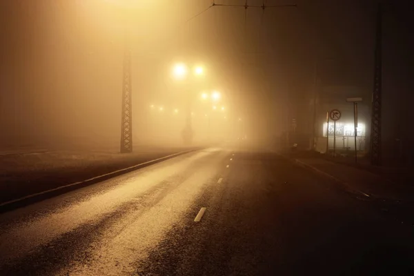 在夜雾中照亮了空旷的沥青路面 黑暗的城市景象 城市景观 拉脱维亚里加工业区 危险驾驶 概念形象 — 图库照片