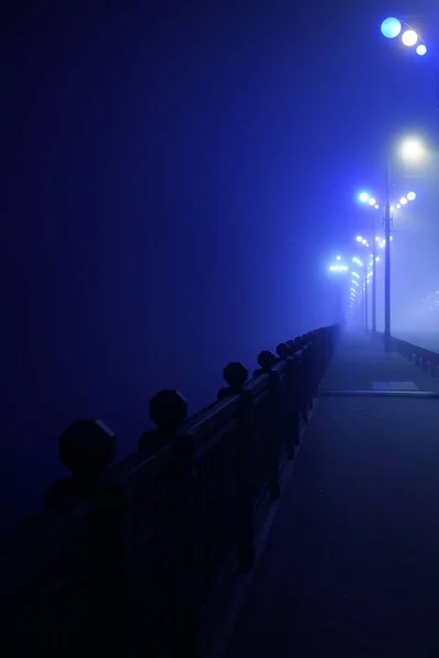在浓雾中 行人走过灯火通明的空石桥 灯笼特写 多加瓦河 拉脱维亚 概念图像 霓虹灯色 — 图库照片