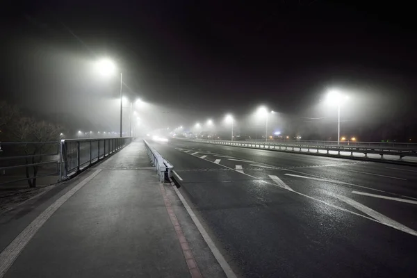 夜雾中 在公路附近一条空旷 灯火通明的自行车道 人行横道 灯笼特写 危险驾驶 娱乐和健康的生活方式主题 拉脱维亚里加 — 图库照片