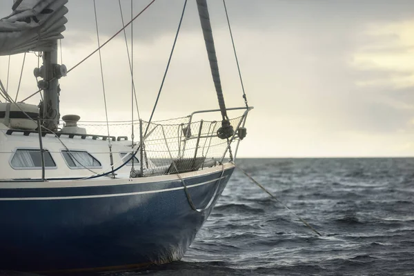 ブルースループは 雷雨の後 暗い空の下で英国の海岸沖に固定されたヨットを操縦しました 荒天時に出航する 劇的な海景 雲の中から太陽の光 — ストック写真