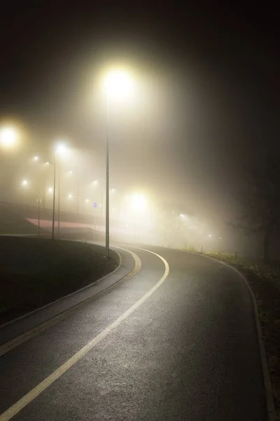 Een Lege Verlichte Fietsweg Met Een Scherpe Bocht Mist Nachts — Stockfoto