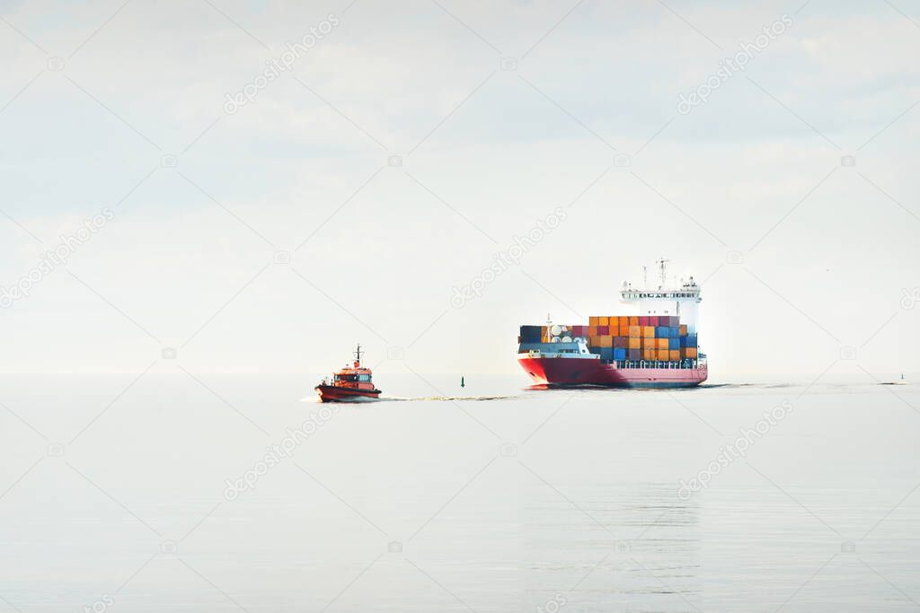 Large cargo container ship being led by the pilot boat. Piloting service. Unknown waters. Global communications, logistics, industry, freight transportation, nautical vessel, nautical route, port