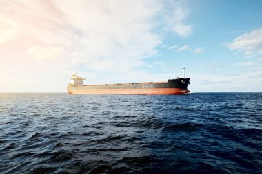Büyük bir yük gemisi (kargo gemisi) Europoort 'tan açık denizlere açılır. Açık mavi gökyüzü ve sirrus bulutları. Rotterdam, Hollanda. Küresel iletişim, lojistik, endüstri teması