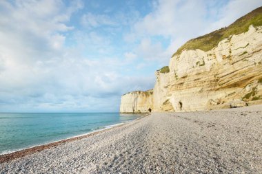 Etretat 'ın beyaz kayalıklarının manzarası panoramik alçak açılı. Açık mavi gökyüzü, gök mavisi su. Fransa, Normandiya 'da yaz tatili. Seyahat yeri, ulusal dönüm noktası, manzara, tarih.