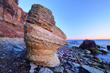 Kışın gün batımında Baltık kıyılarındaki turuncu uçurumlar. Yosun taşları yakın plan. Açık mavi gökyüzü. Idyllic manzara. Seyahat güzergahı. Paldiski, Estonya