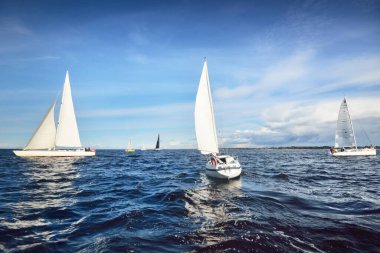 Yelkenli yat yarışı. Modern yelkenliler yakın plan. Fırtınadan sonra dramatik mavi gökyüzü. Muazzam bulut manzarası. Kuzey Almanya, Kiel