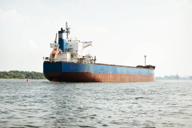 Baltık Denizi 'nden Letonya' nın Riga limanına giden büyük mavi yük gemisi (gemi). Yattan bir manzara. Genel kargo. Küresel iletişim, lojistik, endüstri, nakliye