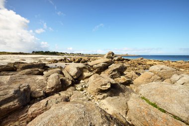 Güneşli bir günde, Lilia Körfezi 'nin Rocky kıyısında, Le Vierge deniz fenerinin yanında. Kadim taşlara yakın çekim. Plouguerneau, Finistre, Brittany, Fransa. Seyahat yerleri, ulusal dönüm noktaları.