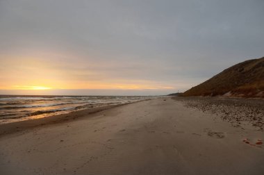 Gün batımında Anholt Adası 'nın kumsal kıyısında. Renkli bulutlu bir manzara. Çevre koruma, eko turizm teması. Kattegat, Danimarka