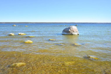 Baltık Denizi 'nin kayalık kıyıları açık mavi gökyüzünün altında, sirrus bulutlarıyla. Kadim taşlara yakın çekim. Bahar. Kasmu doğa rezervi, Estonya. Ekoloji, çevre koruma, eko turizm kavramları