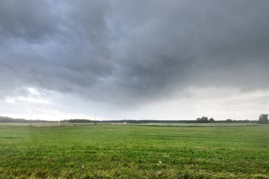 Yağmurdan sonra tarla tarlası. Dramatik gökyüzü, destansı bulutlar. Hava kararsız. - Letonya. Kasırga, fırtına, meteoroloji, ekoloji, iklim değişikliği, doğal olaylar