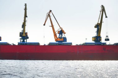 Kömür terminalinde büyük bir kargo gemisi (kargo gemisi), yakın plan. Arka planda iskele vinçleri. Krievu Adası, Riga, Letonya. Yük taşımacılığı, yakıt ve enerji üretimi, çevresel hasar