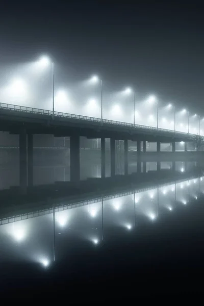 夜雾中灯火通明的空桥的低角度视图 灯笼特写 对称反射在水面上 天然的镜子 Daugava河 拉脱维亚里加 — 图库照片