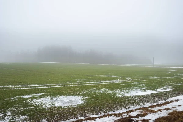 濃い霧の中で暗い空の下で田舎の農業分野 地面に新鮮な雪 ドイツだ コンセプトアート グラフィックミニマリズム エコロジー 地球温暖化 — ストック写真