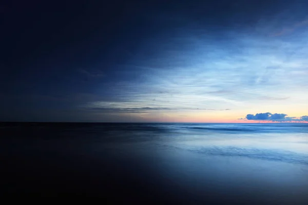 夏日夏至的夜晚 夜空笼罩在波罗的海海岸上空 天空一片星空 乌云弥漫 金色飘逸的阳光长期暴露 神奇的云彩景观 自然模式 抽象艺术 拉脱维亚 — 图库照片