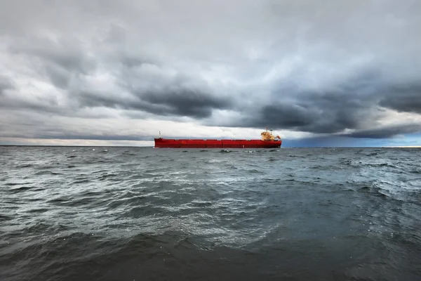 巨大的红色货船在漆黑的日落天空下航行在开阔的海面上 南安普敦英国 多灾多难的云彩 暴风雨天气 全球通信 货物运输 — 图库照片