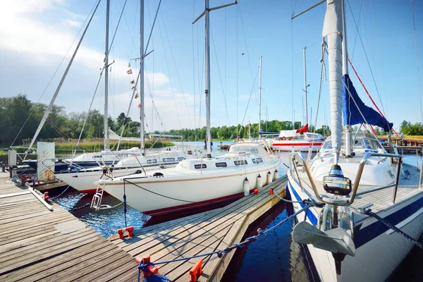 Elegant and modern modern sailing boats (for rent) moored to a pier in a yacht on a clear day. Transportation, cruise, leisure activity, sport and recreation theme. Sweden