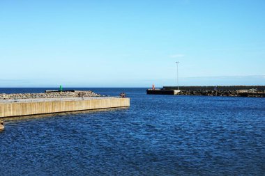 Açık bir yaz gününde Baltık Denizi 'nin boş bir kıyısı. İskeleden bir manzara. Parlak mavi gökyüzü. Ruhnu Adası, Estonya