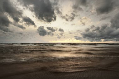 Baltık Denizi 'nin üzerindeki kara bulutlu gökyüzü, Danimarka. Fırtına dalgaları ve renkli bulutlar. Uzun pozlama