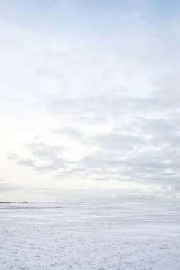 Gün batımında karla kaplı kırsal alanın panoramik manzarası. Akşam bulutları. Norveç